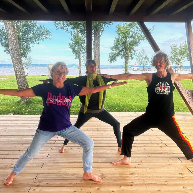 Drei Yogalehrer machen Yoga auf der Yoga-Plattform am Südstrand von Podersdorf am See